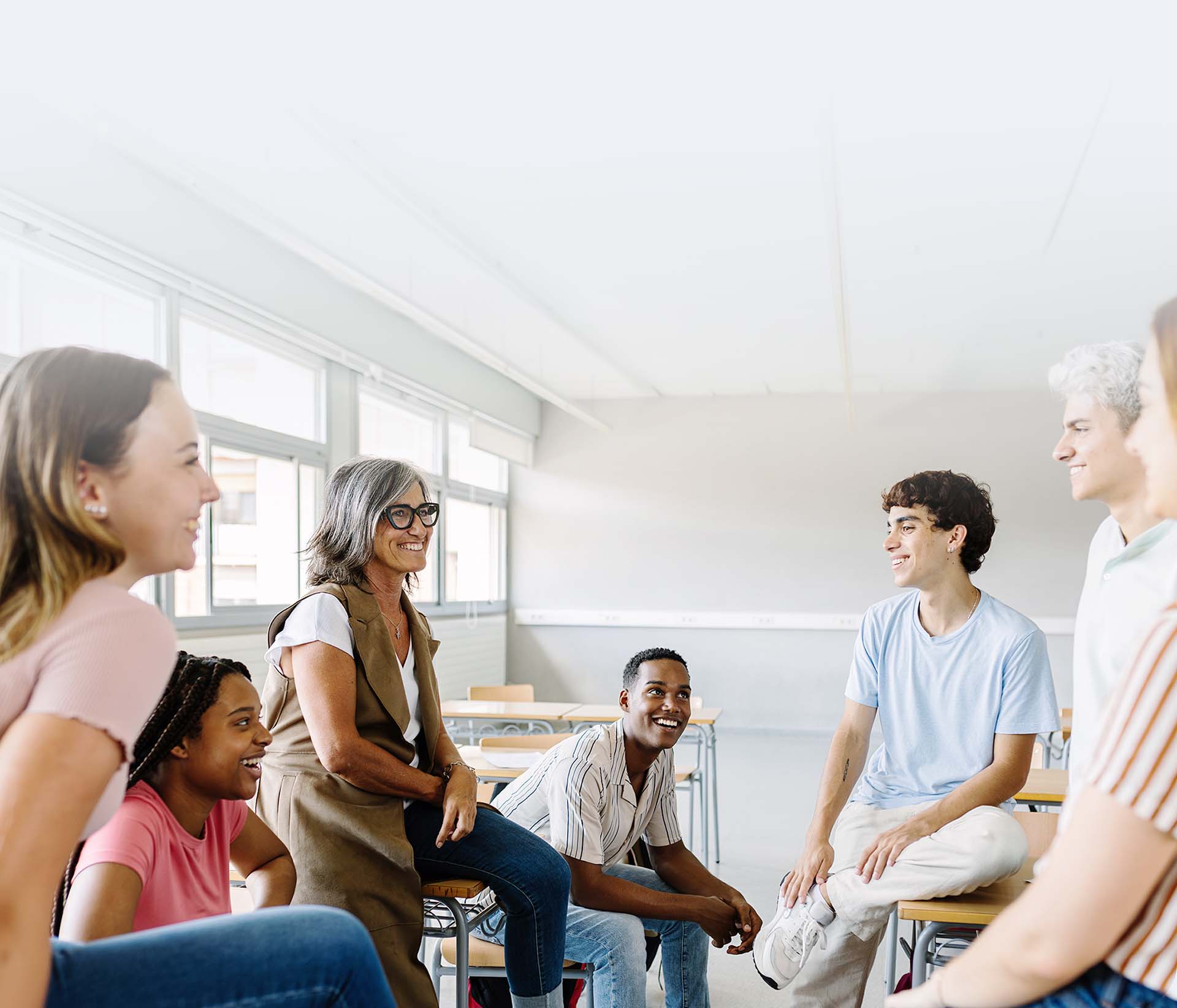 Fotografía de un grupo de docentes tiendo una reunión en el aula de un colegio.