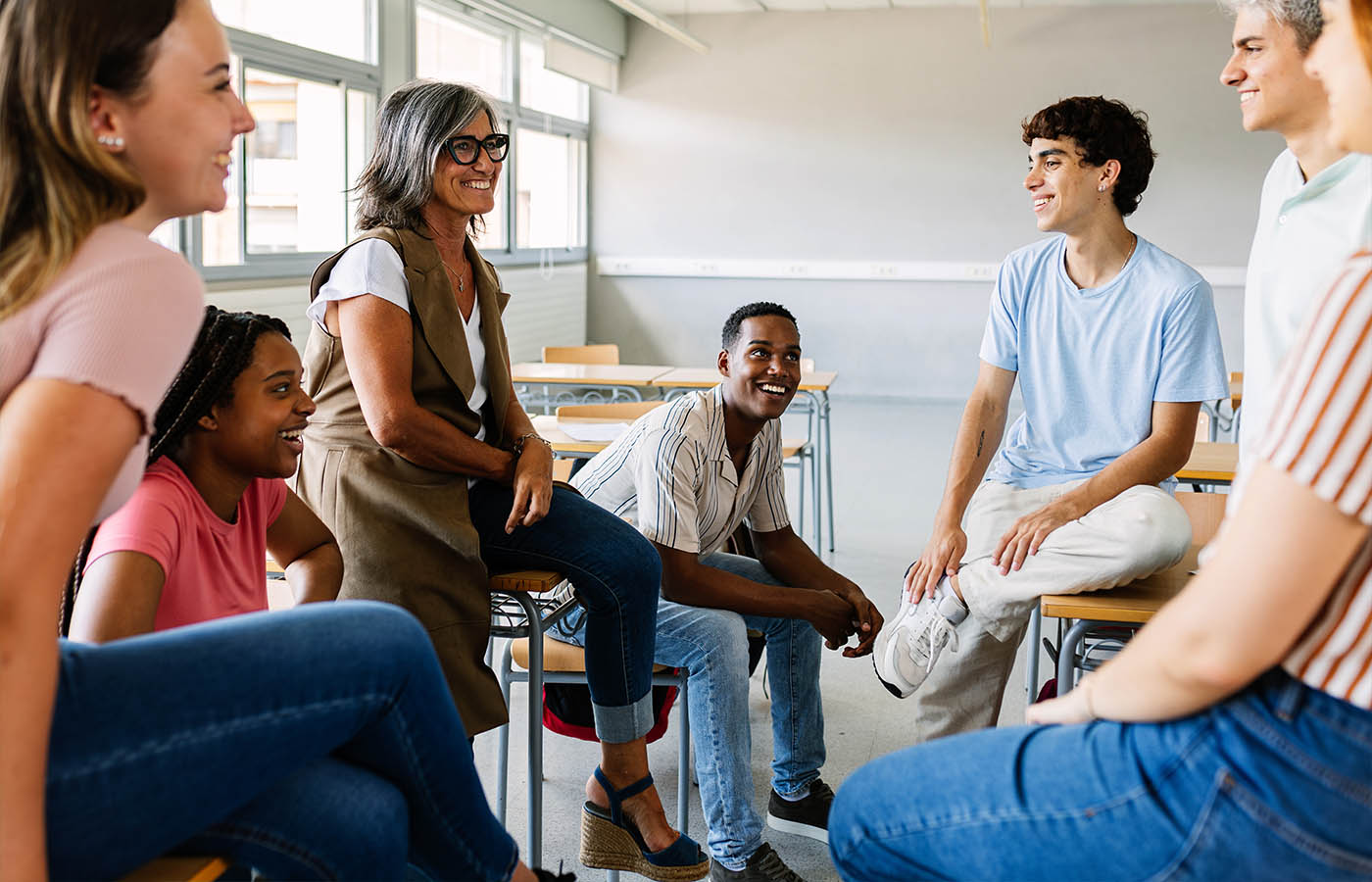 Fotografía de un grupo de docentes tiendo una reunión en el aula de un colegio.